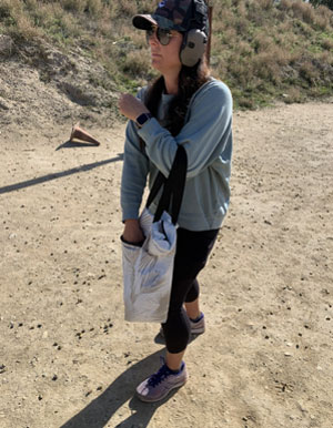 woman reaching into a bag at a firearm course